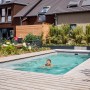Mann schwimmt im Pool, beheizt mit Summer Fun Green Energy Plus 10 Wärmepumpe.
