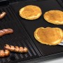 Char-Broil Grillplatte aus Gusseisen mit Würstchen und Pancakes auf einem Grill.