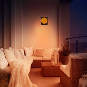 MegaLight Sunball Solar-LED-Wandleuchte mit Sensor, spendet warmes Licht auf einer Terrasse mit Lounge-Möbeln.