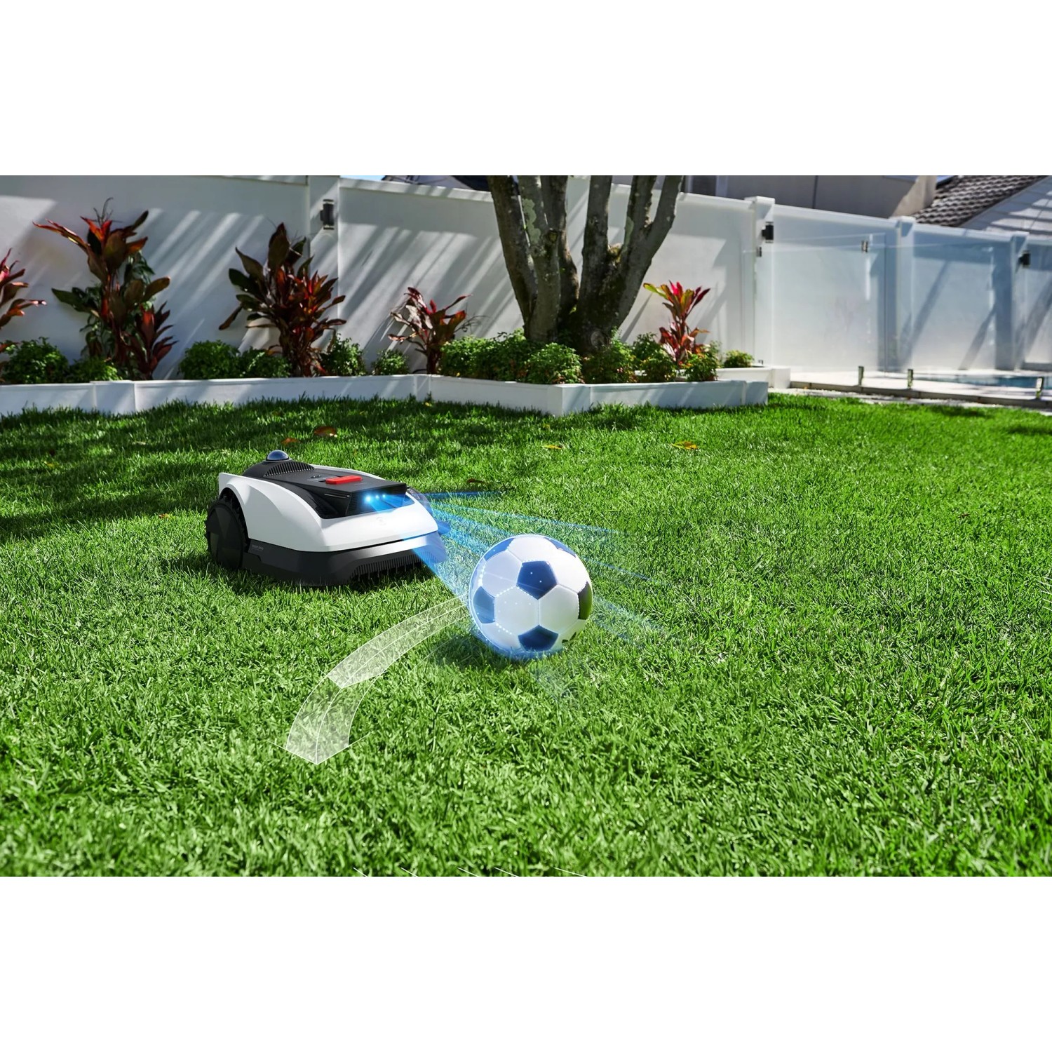 Ecovacs Mähroboter Goat O1200 auf Rasen mit Fußball, weiß-schwarz. Intelligente Rasenpflege.