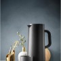 WMF Impulse Isolierkanne 1,0l in mattem Schwarz mit passender Tasse auf Holzplatte. Perfekt für Kaffee & Tee.