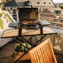 Enders Elektrogrill eUrban Pro 2 Turbo Mobil auf Tisch mit Grillgut, im Hintergrund Gebäude.