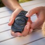 Paulmann Plug & Shine Controller in Schwarz mit Fernbedienung in Händen, zur Steuerung von Außenbeleuchtung.
