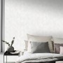 Erismann Vliestapete Elle Decoration mit Wellenmuster in Hellgrau an Schlafzimmerwand.