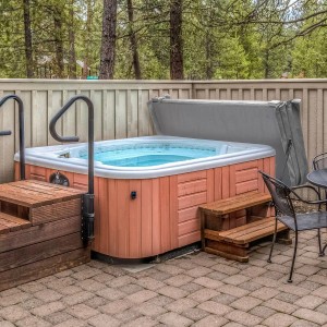 Graue Monstershop Whirlpool Abdeckung 2,2m, teilweise geöffnet, mit Isolierung und Sicherheitsgurten.