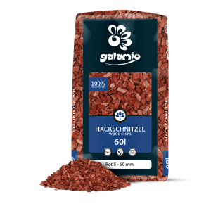 Rote Galamio Holzhackschnitzel 60l im Beutel, daneben ein Haufen Mulch. Ideal für Garten und Beete.