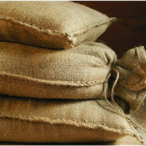Stapel aus 10 unbefüllten Jute Sandsäcken, robust und wiederverwendbar.