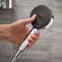Hansgrohe Pulsify Select S 105 Handbrause Chrom mit 3 Strahlarten in der Hand gehalten.