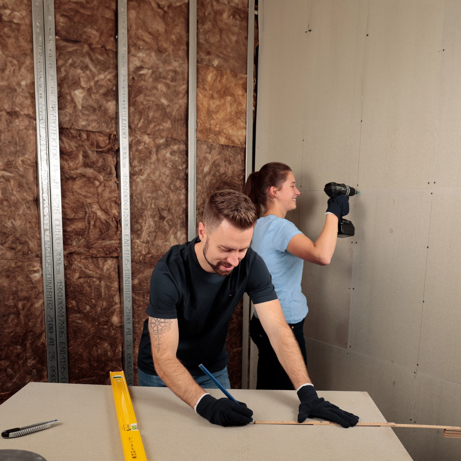 Zwei Personen verarbeiten eine KlimaTec RapidBoard Leichtbauplatte an einer Wand.