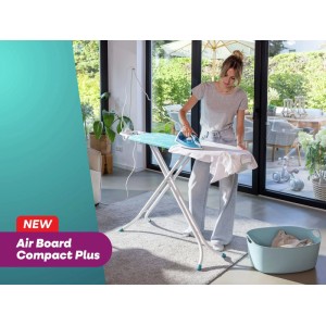 Frau bügelt auf Leifheit Bügeltisch AirBoard M Compact Plus, türkisfarben mit weißem Gestell, im Wohnraum.