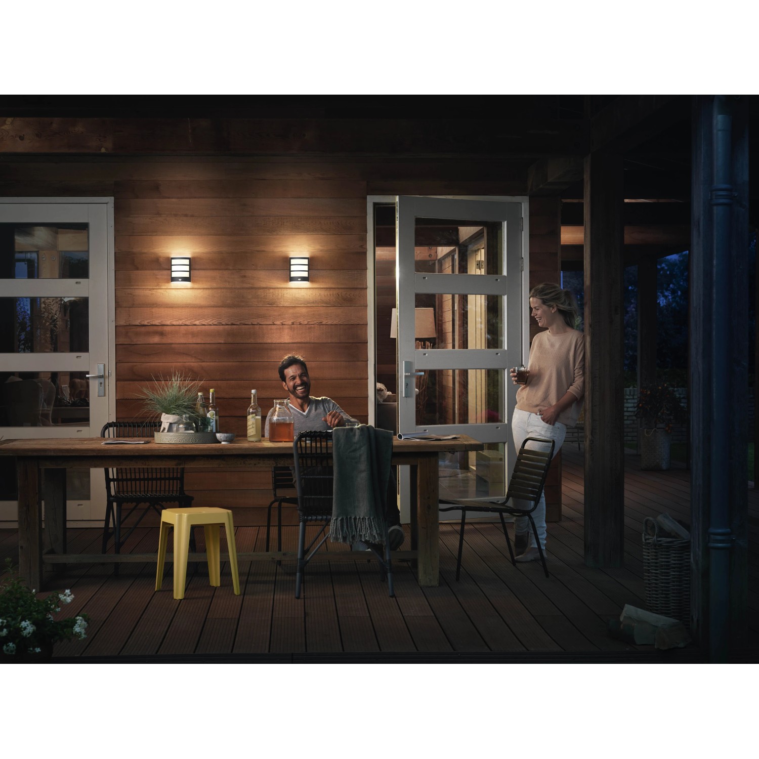 Anthrazitfarbene Philips Python LED Aussenwandleuchte mit Bewegungssensor an Holzfassade.