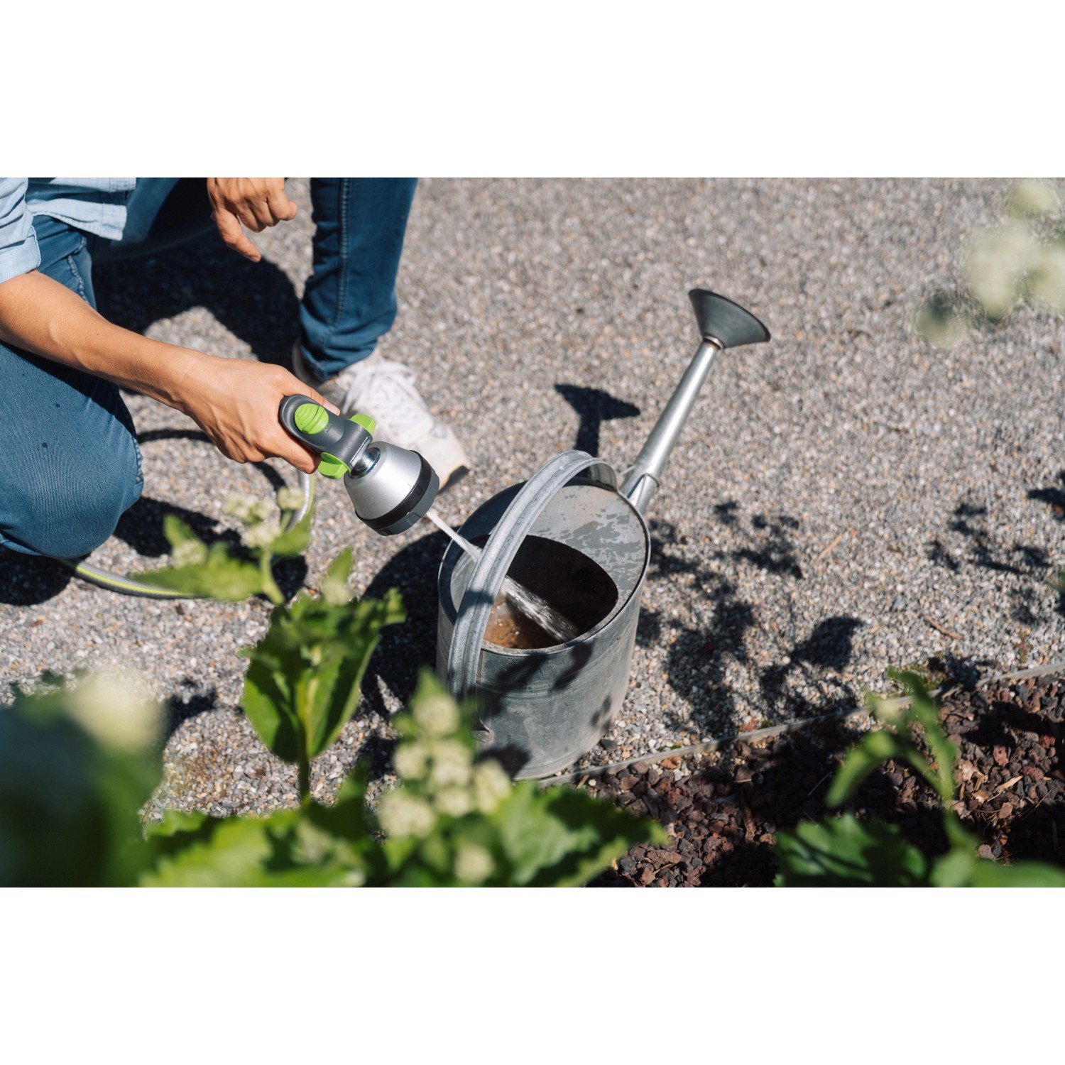 Geka Multibrause Plus 3S Grau beim Befüllen einer Gießkanne im Garten.