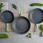 Fackelmann Ecolution Pfannen-Set, grau-grün, mit Gemüse dekoriert.