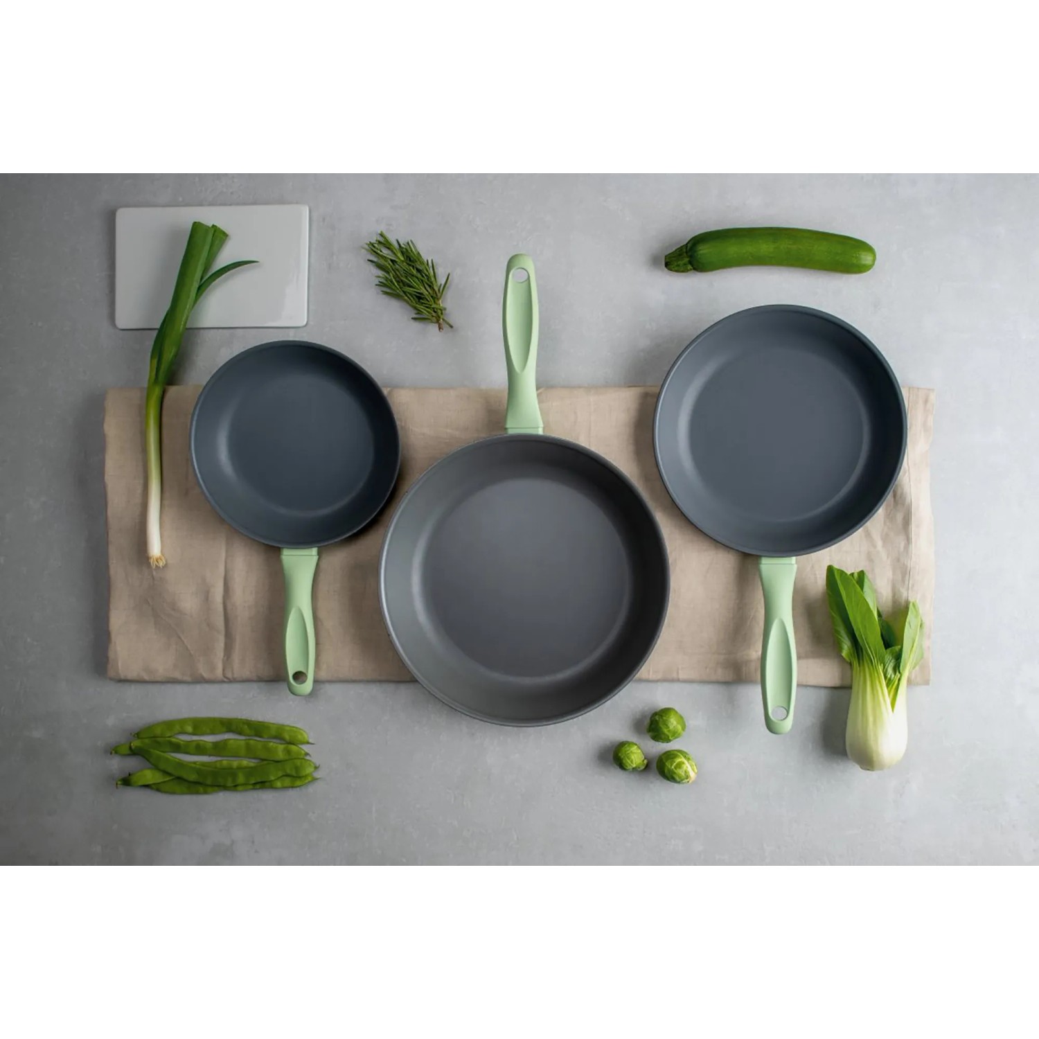 Fackelmann Ecolution Pfannen-Set, grau-grün, mit Gemüse dekoriert.