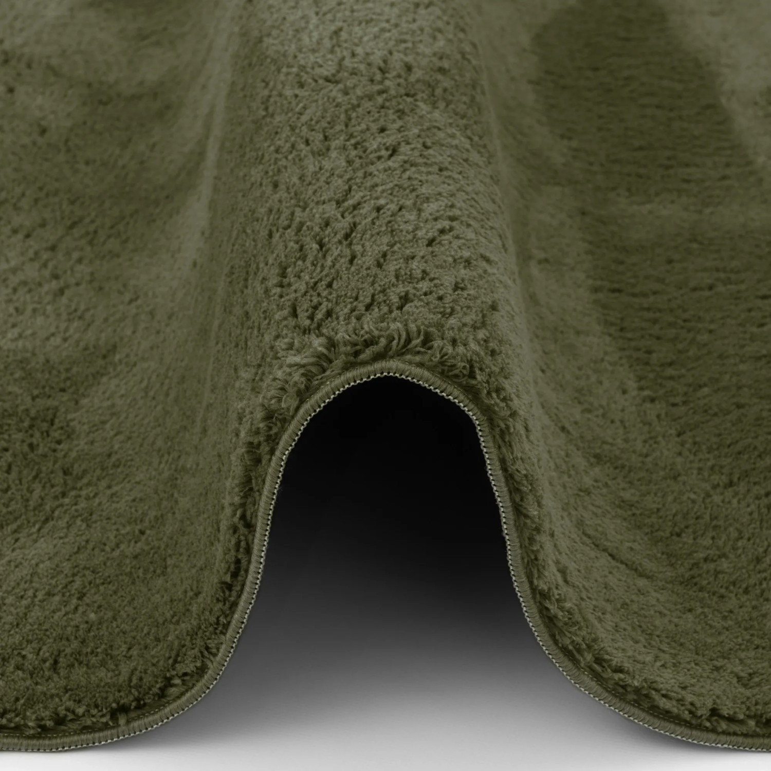 Detailaufnahme des tannengrünen Pergamon Luxus Fellteppichs (80x150cm) mit weicher Oberfläche.