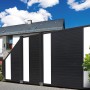 Anthrazitfarbenes Sichtschutzzaun-Anschlusselement Duo (180x90/90 cm) mit weißen PVC-Streifen vor Haus.