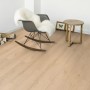 Heller Laminatboden Ararat Oak Breitdiele Eiche im Wohnraum mit Schaukelstuhl und Beistelltisch.