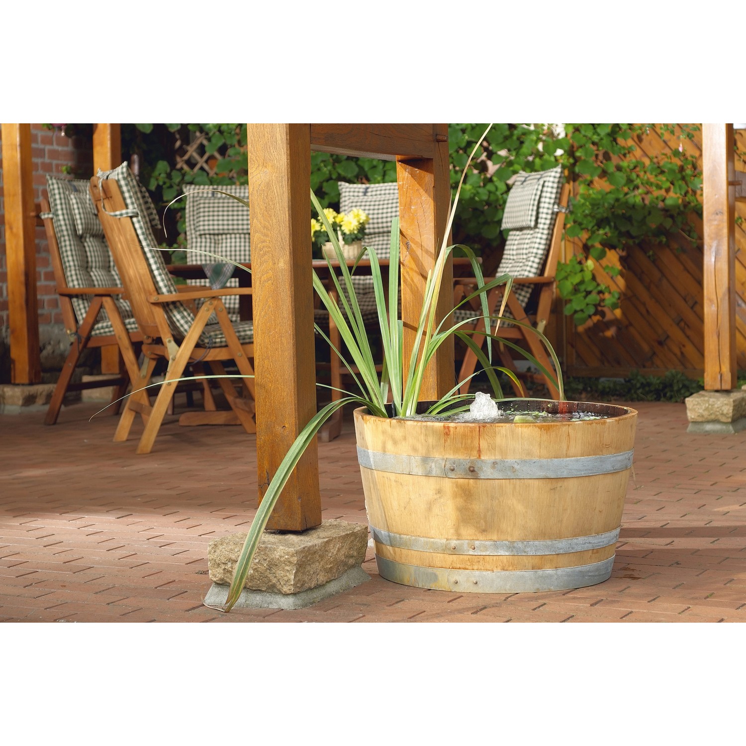 Filtral UVC 6000 Teichfilter im Holzfass mit Wasserspiel im Garten.