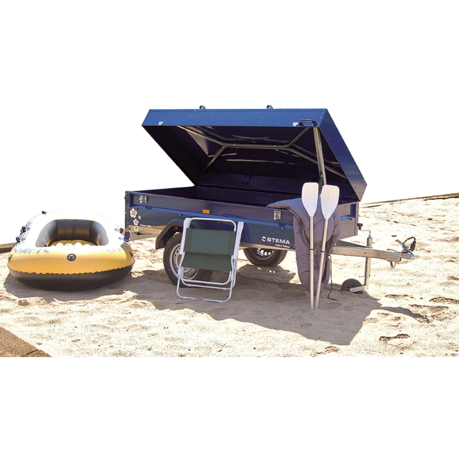 Stema Blue Man 750 Autoanhänger mit Deckel, Campingausrüstung und Schlauchboot am Strand.