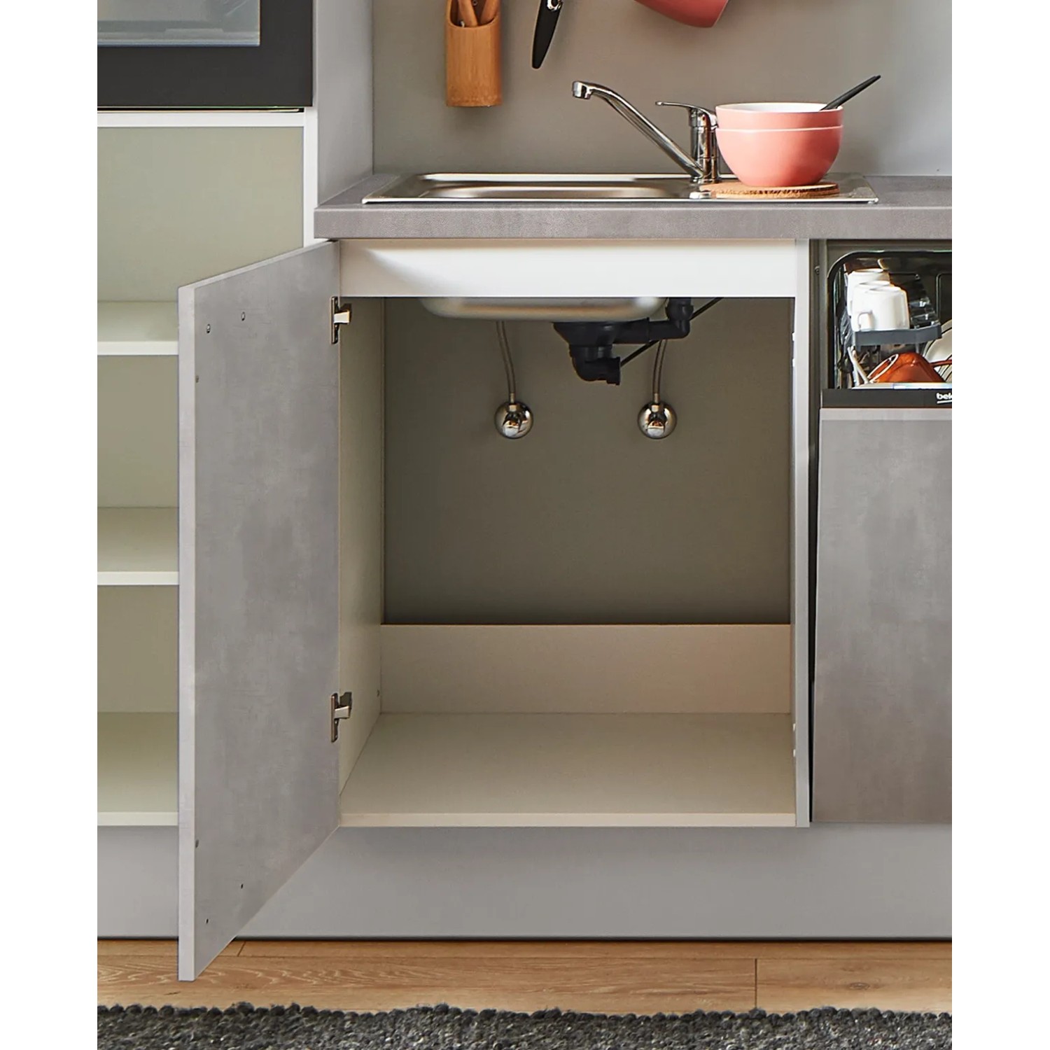 Küchenzeile Beton Perlgrau, Spülenschrank geöffnet mit Blick auf Spüle und Anschlüsse.
