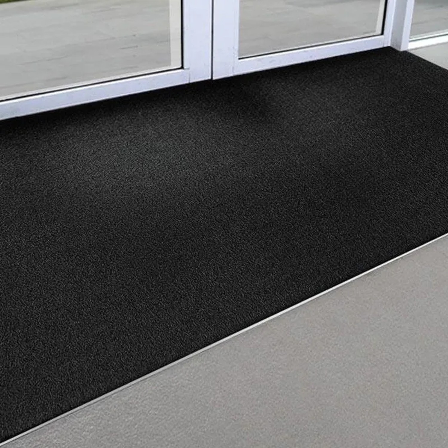 Schwarze KARAT Kokosmatte 40x60 cm als Eingangsmatte vor einer Tür. Fußabtreter aus Naturfasern.