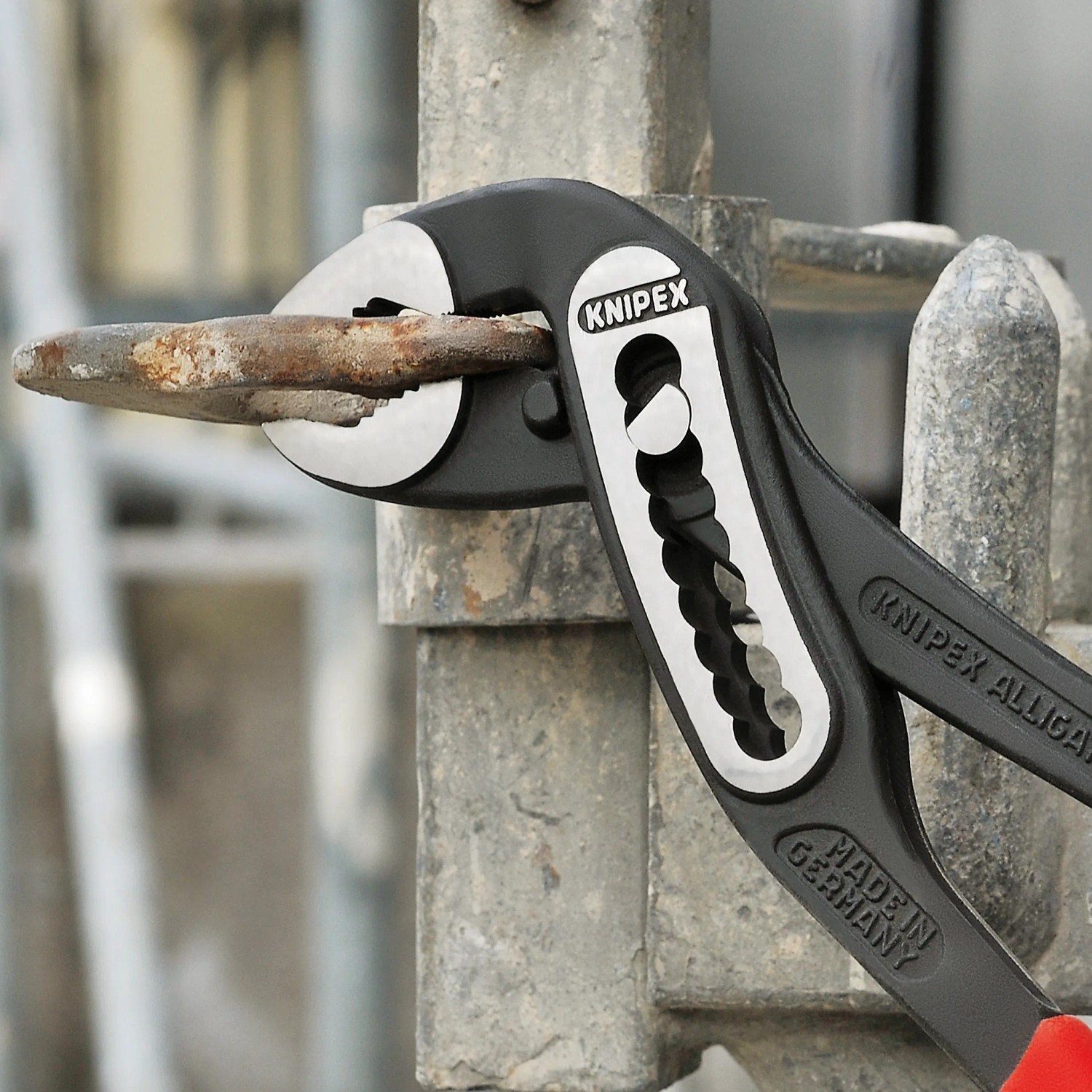 Knipex Alligator Wasserpumpenzange, 300 mm, schwarz atramentiert, greift ein Metallstück.