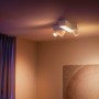 Weiße Philips Hue Centris Cross LED-Deckenleuchte mit 3 Spots und Lightbar im Wohnraum.