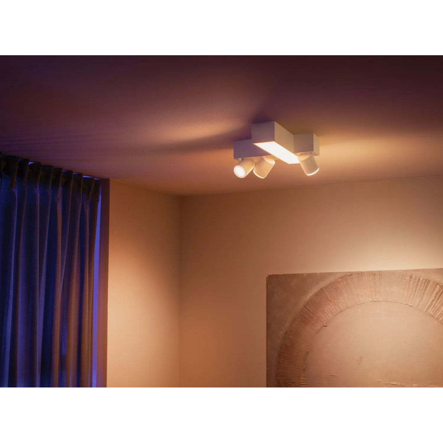 Weiße Philips Hue Centris Cross LED-Deckenleuchte mit 3 Spots und Lightbar im Wohnraum.
