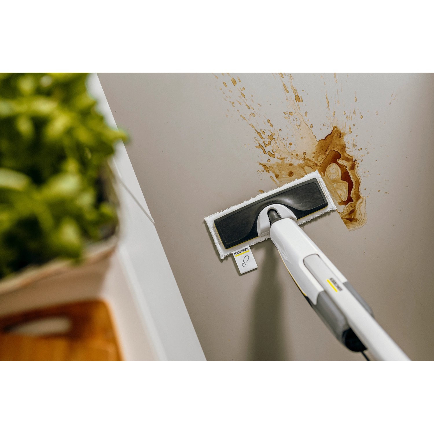 Kärcher SC 2 Dampfmopp beim Reinigen einer Wand mit Flecken.
