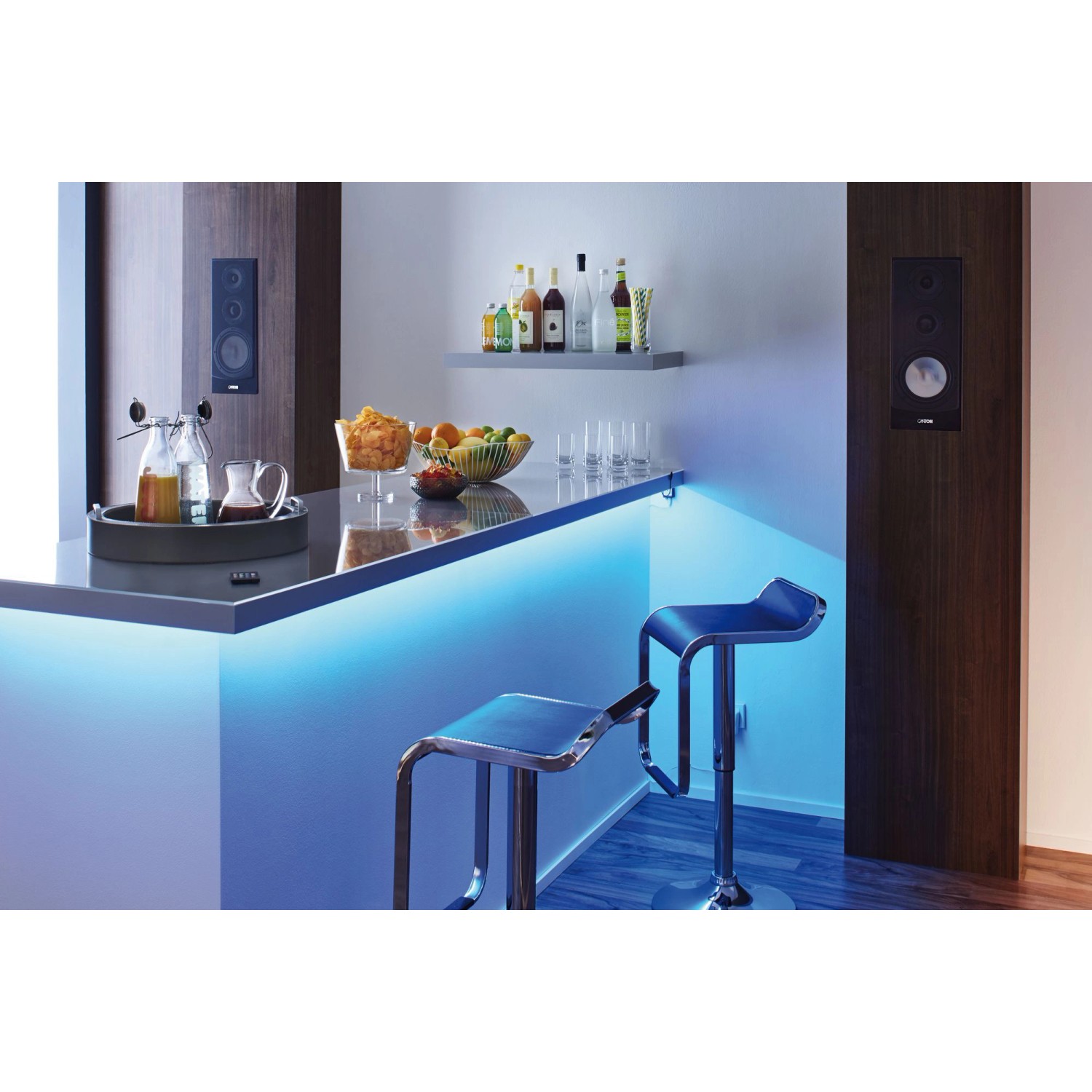 YourLED Lights and Sound Set von Paulmann: RGB LED-Streifen beleuchten eine Bar mit Hockern und Lautsprechern.