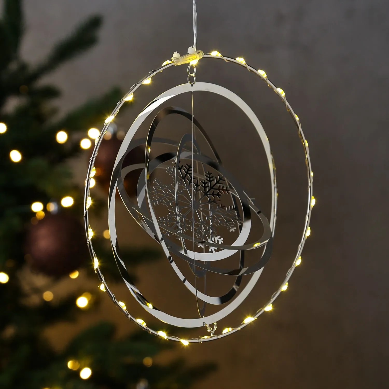 Silberner LED Kreis mit 3D Schneeflocke als Weihnachts-Dekohänger. Warmweiße Lichter, ideal für Fensterdeko.