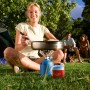 Frau kocht mit Evocamp Gaskartusche auf Campingkocher im Freien.