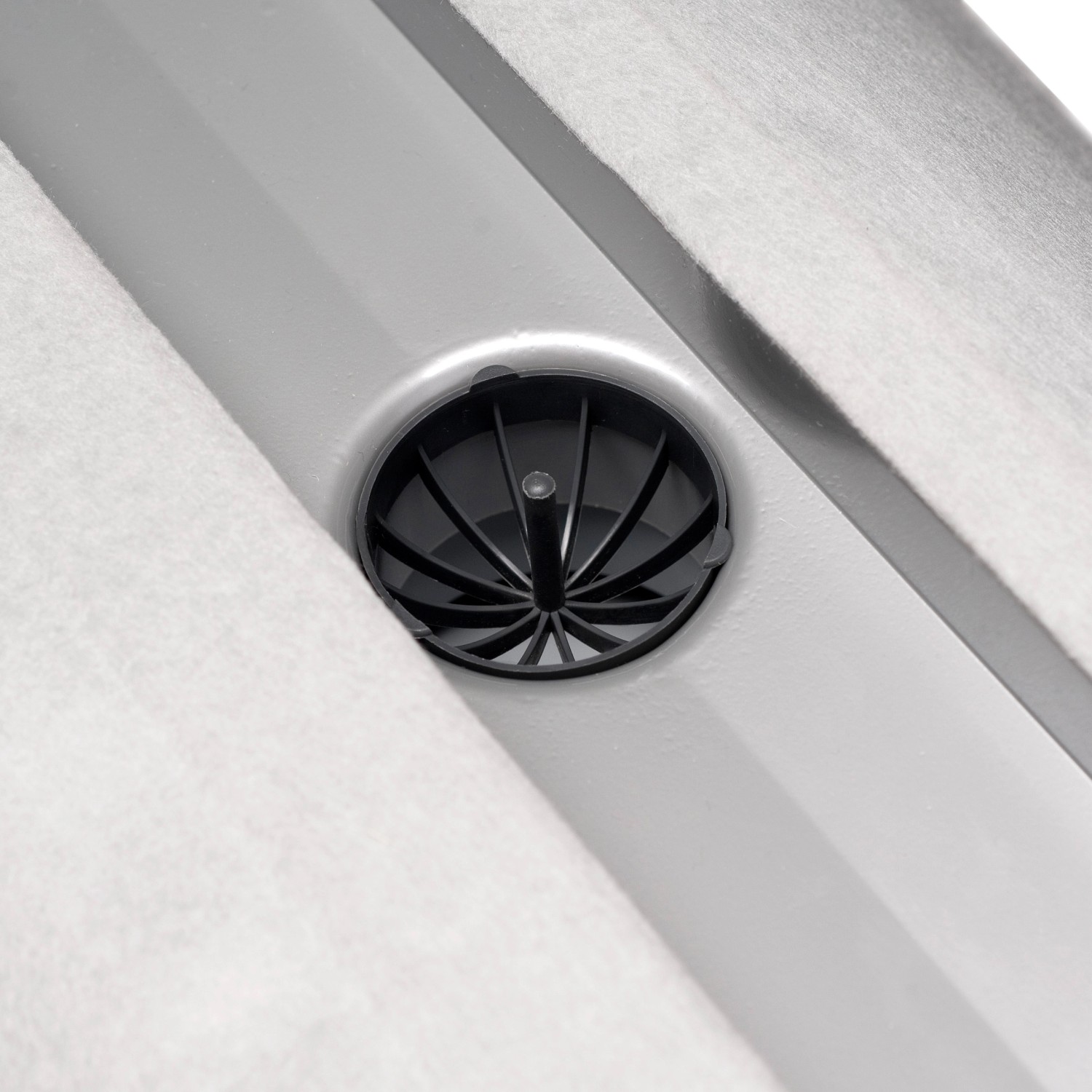 Detailaufnahme: Schütte Duschrinne mit schwarzem Siphon und Edelstahlabdeckung.