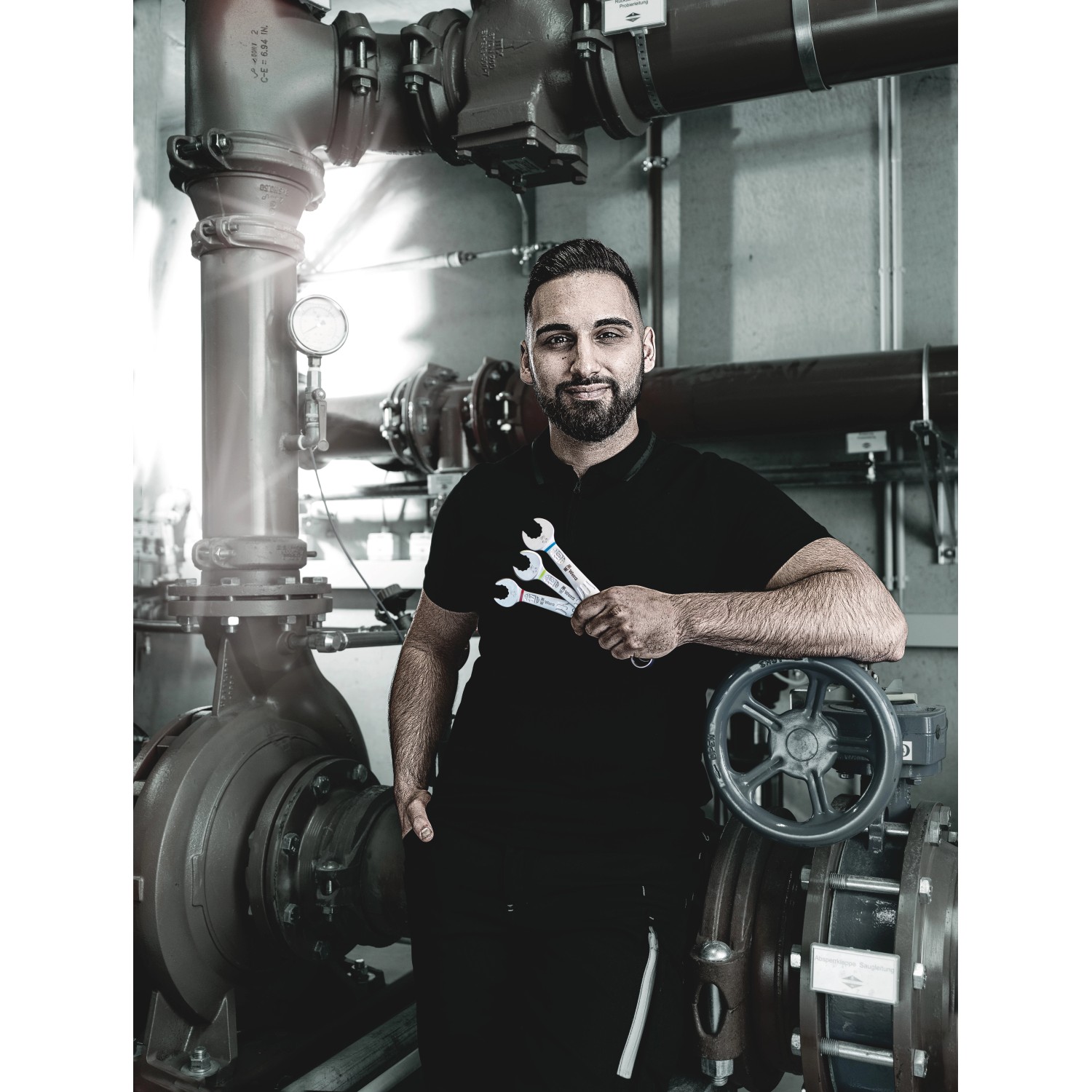 Mann mit Wera Ringmaulschlüssel Joker 15 mm vor industriellem Hintergrund.
