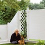 Weißes T&J Kunststoff-Zaunelement Lightline 180x180 cm mit Frau und Hund im Garten.