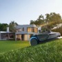 Sunseeker Mähroboter S4 für 1000 m² im Einsatz auf einer Rasenfläche vor einem Wohnhaus.