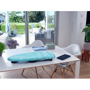 Leifheit AirBoard Compact Tischbügelbrett auf einem Tisch, mit Wäsche und Bügeleisenablage.