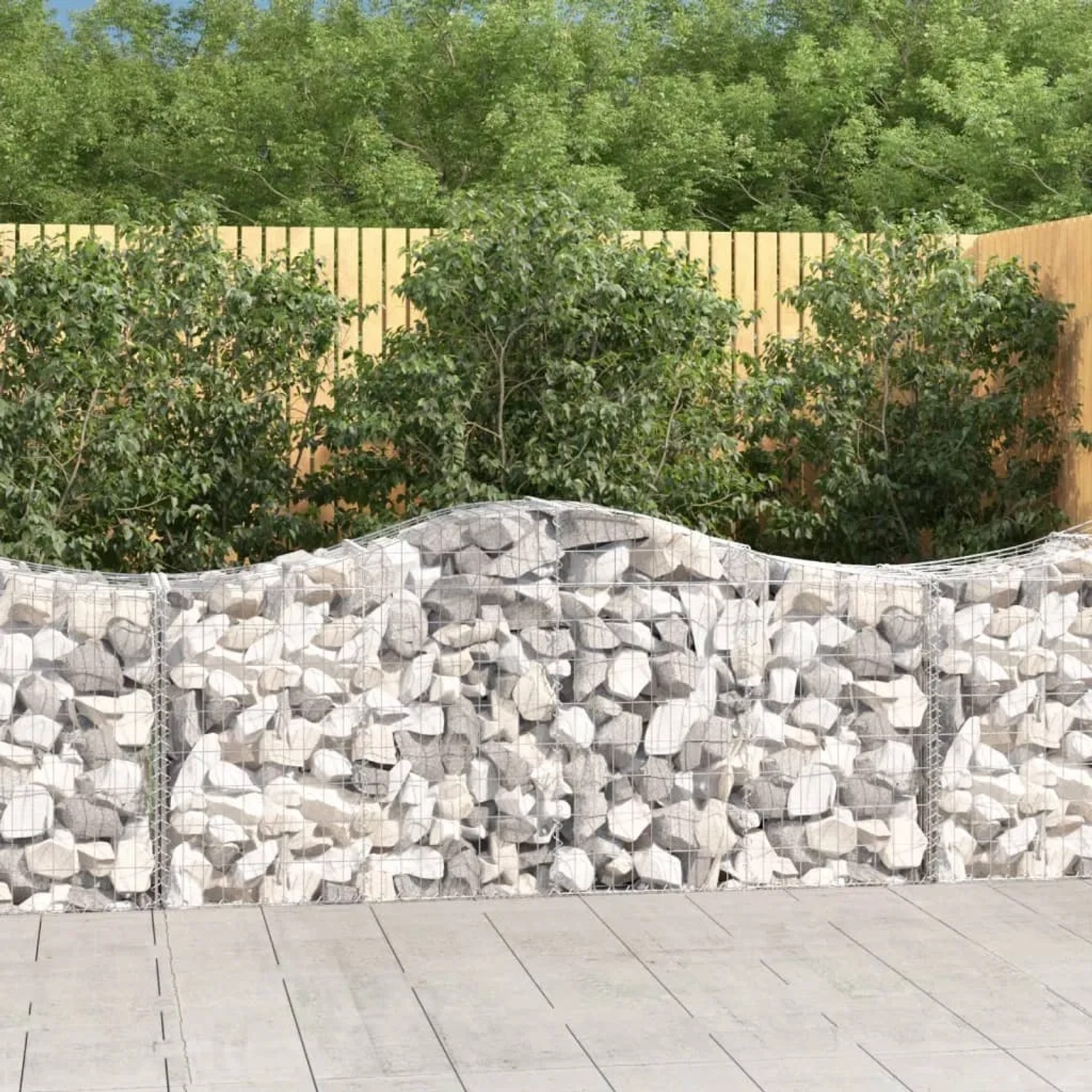 Gefüllte Gabionen mit Hochbogen als dekorativer Sicht- und Lärmschutz im Garten.