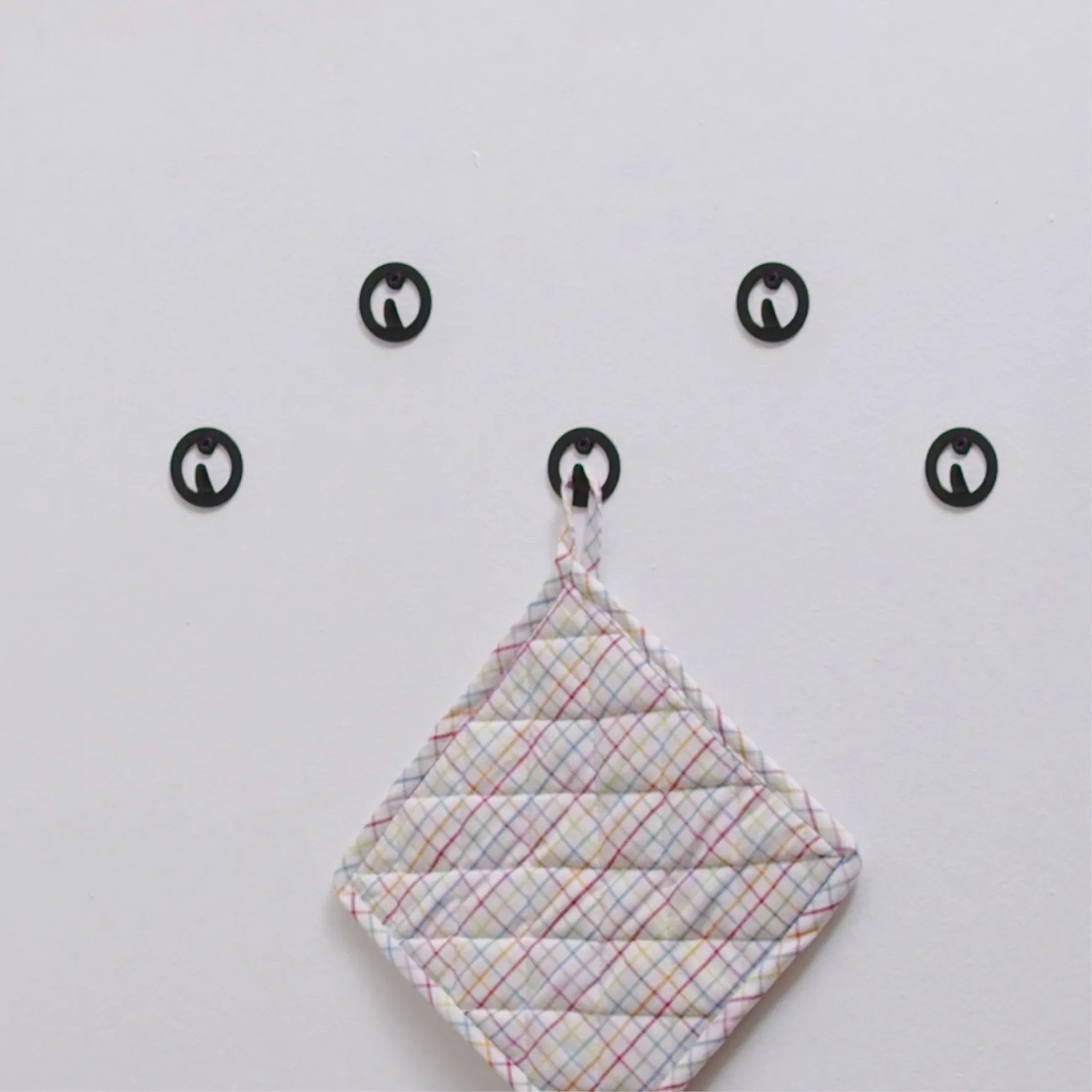 Wandhaken Hooks4home Retro, schwarz matt, Stahl, mit Topflappen an der Wand.