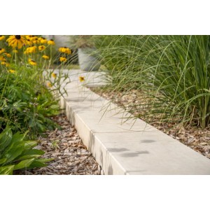 Diephaus Blockstufe Emlan Grau als Garten-Einfassung, schlichtes Design, feinporige Oberfläche, umgeben von Grünpflanzen.