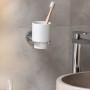 Wenko Zahnputzbecherhalter Isera, silber glänzend mit weißem Keramikbecher und Zahnbürste.