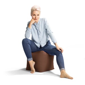 Frau sitzt auf braunem Sitting Point Hocker (60 l). Bequemer Sitzsack für Indoor & Outdoor.