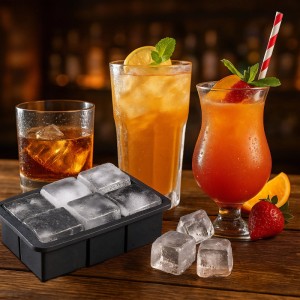 Schwarze XXL Silikon Eiswürfelform mit 6 großen, klaren Eiswürfeln. Daneben 3 lose Würfel und gekühlte Getränke. Perfekt für Whisky & Cocktails.