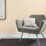 Beige Vliestapete von Erismann, Design Guido Maria Kretschmer, im Raum mit Sessel und Deko.