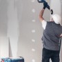 Mann schleift Decke mit Exzenterschleifer und Bosch Expert Schleifnetz-Set Starter Kit M480.