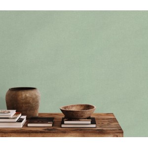 Grüne Erismann Vliestapete Forest Dreams Modern Pastels an der Wand, kombiniert mit Deko-Elementen auf einem Holztisch.