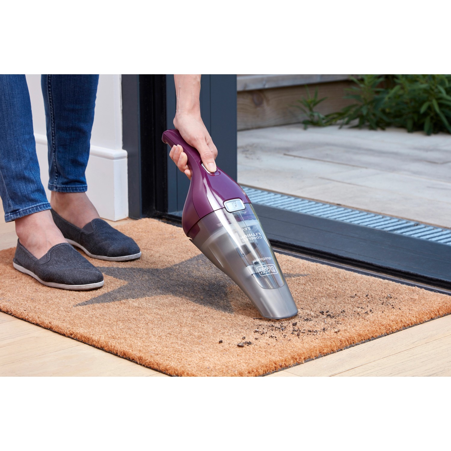 Black+Decker Akku-Handstaubsauger NVC115W im Einsatz auf einer Fußmatte.