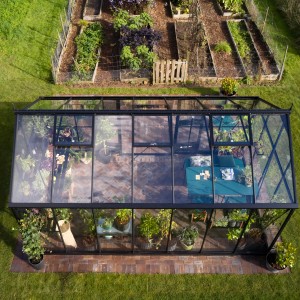 Juliana Gewächshaus Jubii 60-15 Schwarz, Vogelperspektive. Begehbares Gewächshaus mit Pflanzen und Gartentisch.