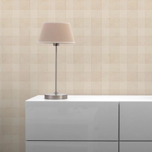 Beige Vliestapete mit dezentem Karomuster an einer Wand, kombiniert mit weißem Schrank und Lampe.