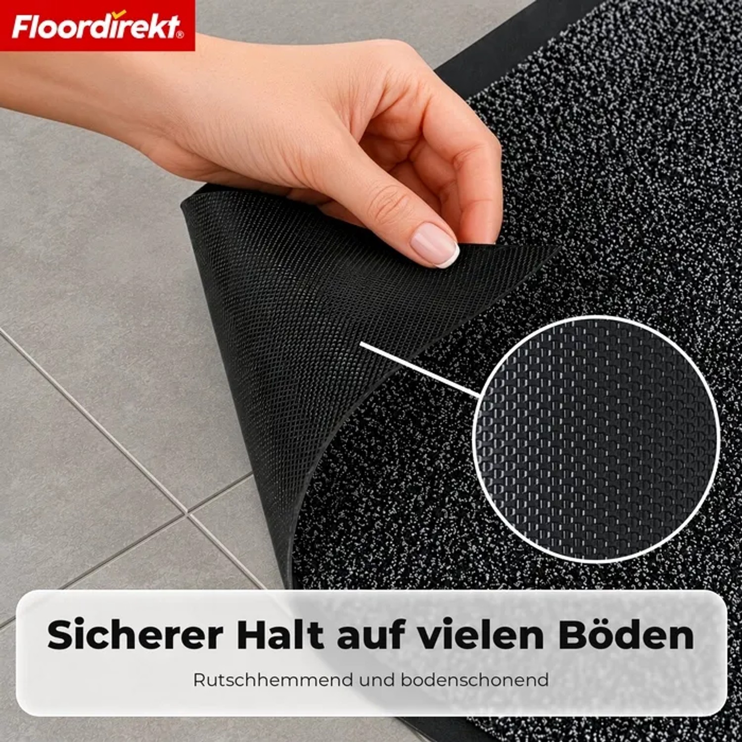 Anthrazitfarbene Floordirekt Schmutzfangmatte mit melierter Oberfläche. Hand zeigt rutschfeste TPE-Rückseite auf Fliesenboden.